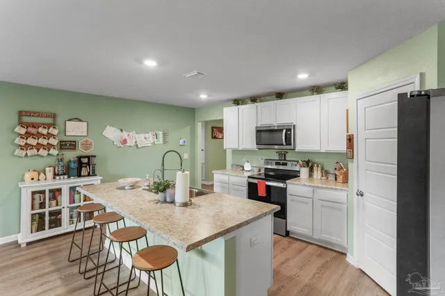 a kitchen with kitchen island a stove a table and chairs