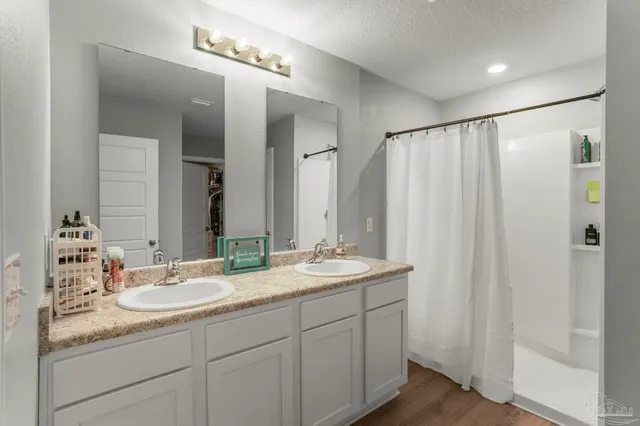 a bathroom with double sink and a mirror