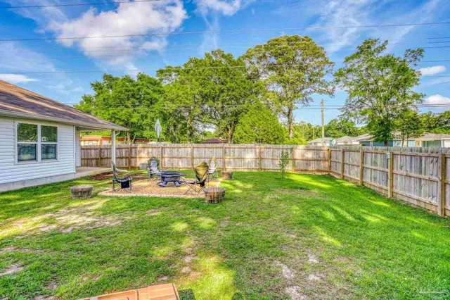 a view of a backyard with table and chairs and wooden fence