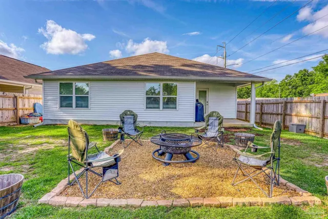 a backyard of a house with table and chairs