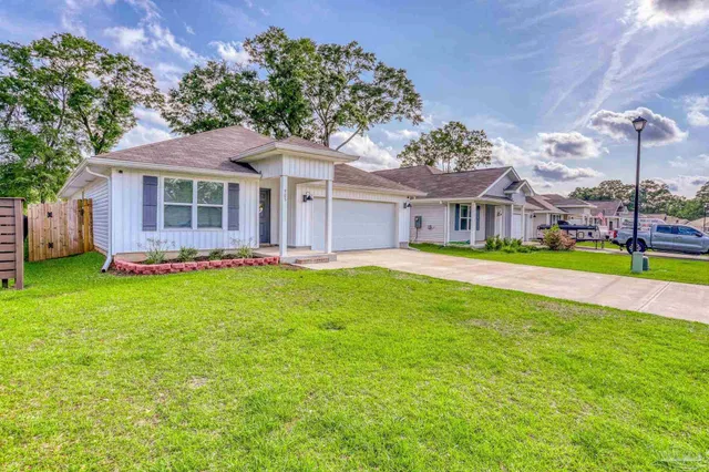 a front view of a house with a garden and plants