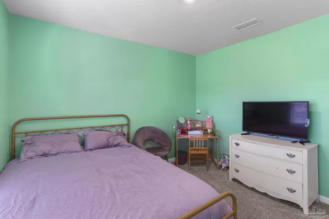 a bedroom with a bed and flat screen tv