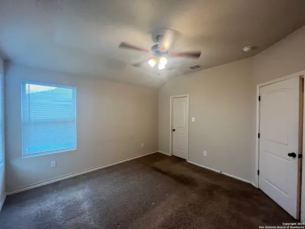 a view of an empty room and a ceiling fan
