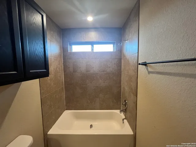 a bathroom with a granite countertop sink and a toilet