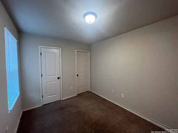 an empty room with a fan and a window