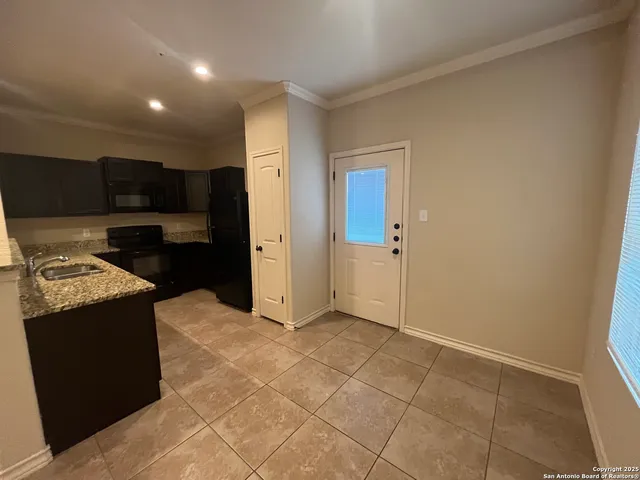 a large kitchen with granite countertop a cabinets and a stove top oven