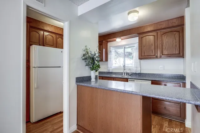 a kitchen with stainless steel appliances granite countertop a refrigerator a sink and a stove