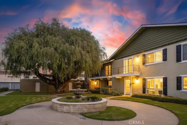 a front view of a house with a garden and trees
