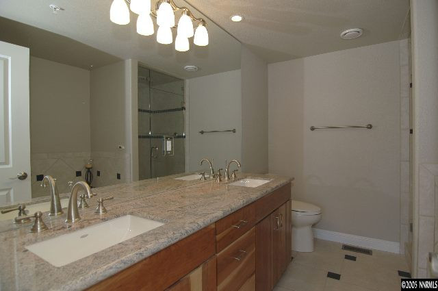 1990 Dickerson Road Reno, NV 89503 - Photo 6 of 9 a bathroom with a granite countertop sink a toilet and a mirror