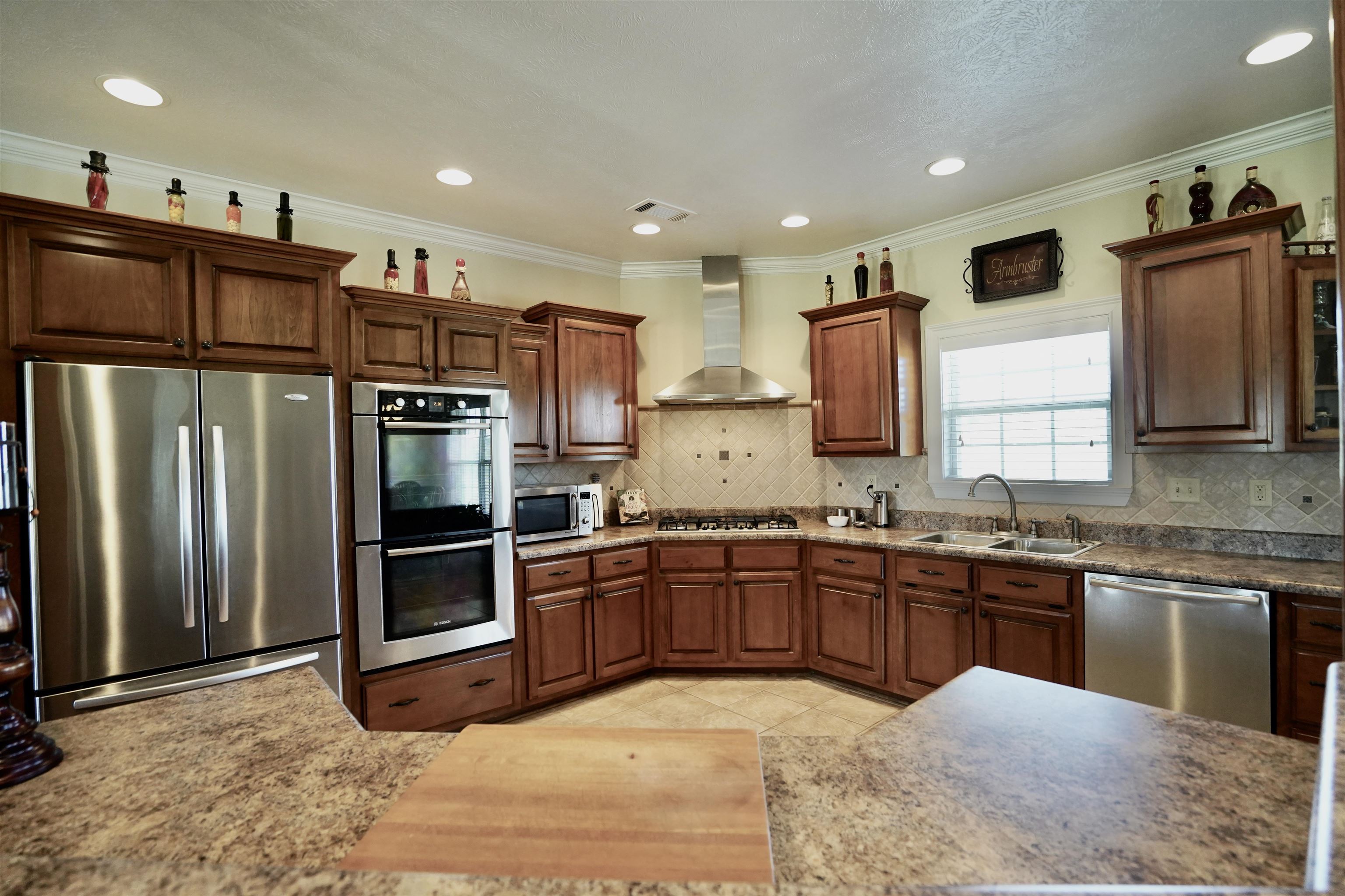 4556 Gainsville Road Mason, TN 38049 - Photo 22 of 33 Kitchen featuring stainless steel appliances, wall chimney exhaust hood, ornamental molding, and sink
