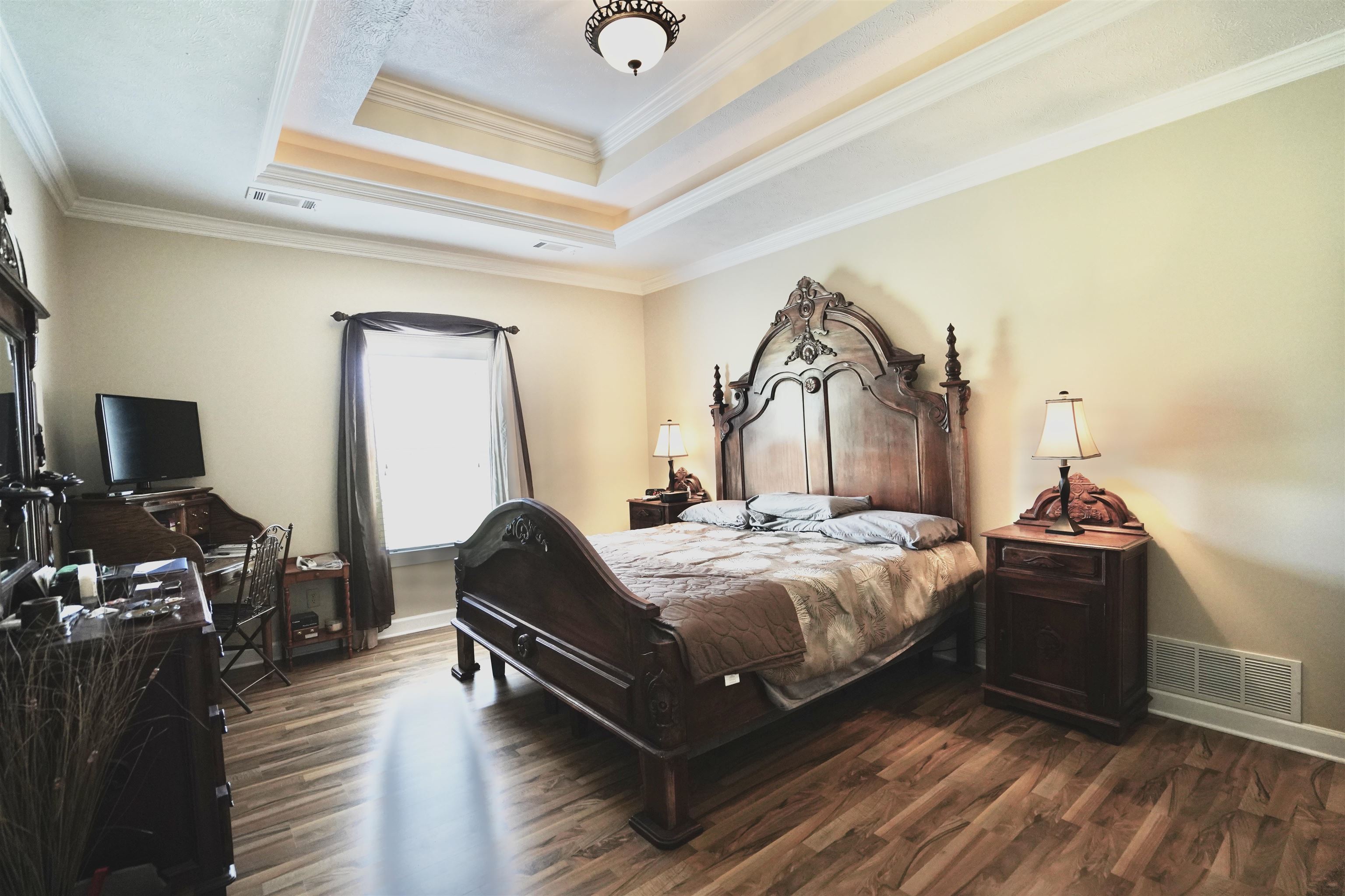 4556 Gainsville Road Mason, TN 38049 - Photo 28 of 33 Bedroom with a tray ceiling, ornamental molding, and dark hardwood / wood-style flooring