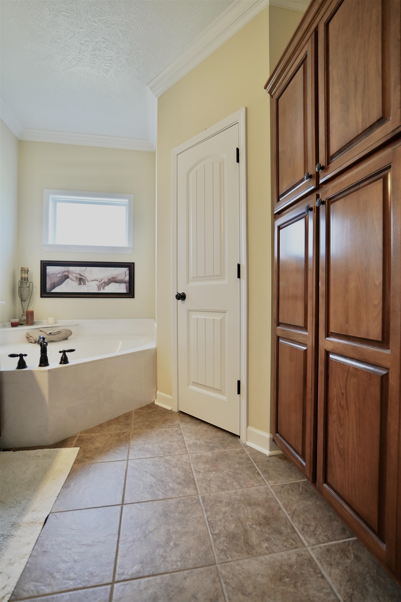 4556 Gainsville Road Mason, TN 38049 - Photo 29 of 33 Bathroom with a textured ceiling, crown molding, a bath, and tile patterned floors
