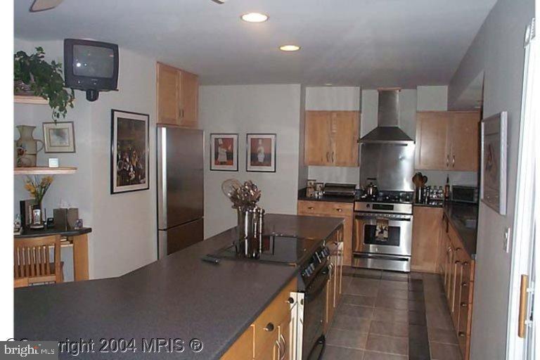 a kitchen with stainless steel appliances granite countertop a stove top oven a sink a dining table and chairs