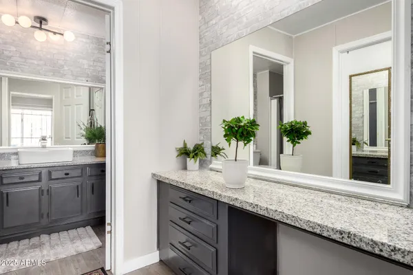 a bathroom with a granite countertop sink and a mirror