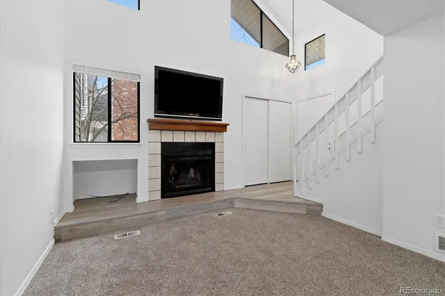 a view of an empty room with a fireplace and a window