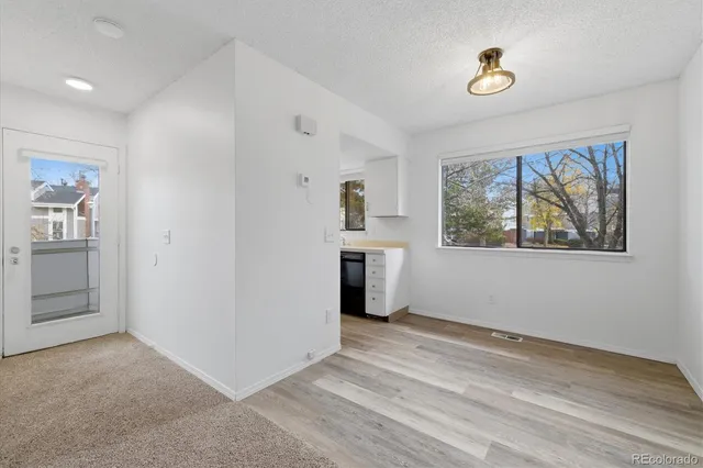 a view of empty room with wooden floor and window