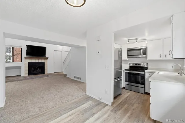a kitchen with granite countertop a stove top oven and refrigerator