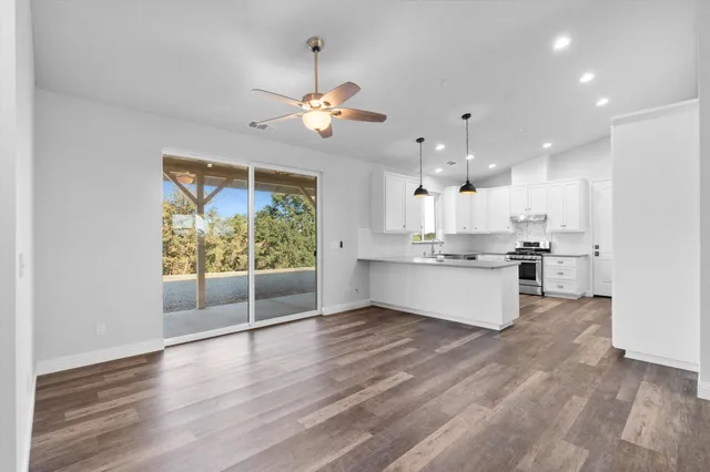 a view of kitchen with granite countertop cabinets stainless steel appliances and a fireplace