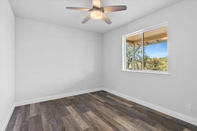 an empty room with a window and wooden floor
