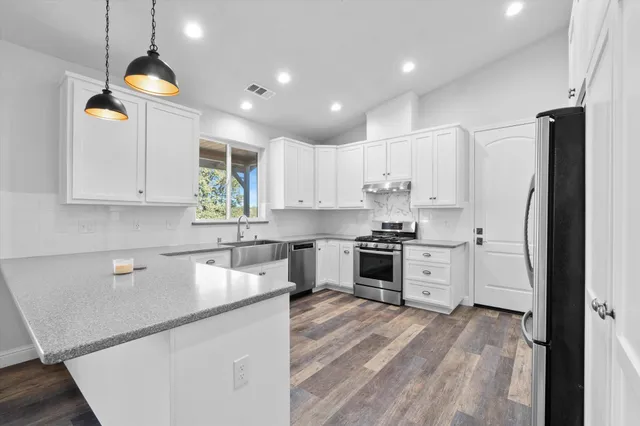 a kitchen with a refrigerator a sink and cabinets