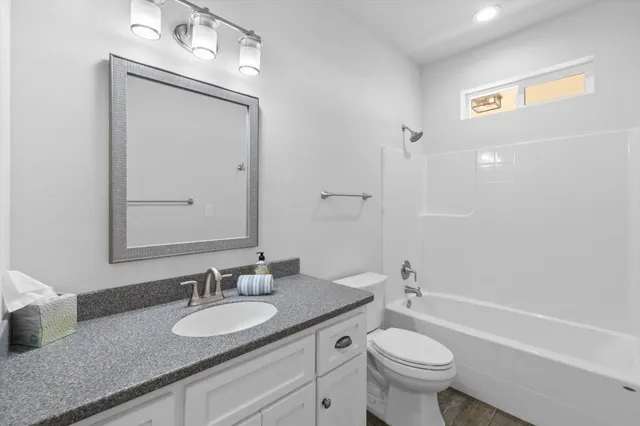 a bathroom with a granite countertop sink toilet and a mirror