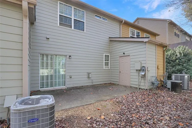 a backyard of a house with chairs and a potted plant