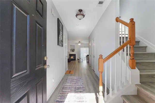 a view of a hallway with wooden floor and staircase