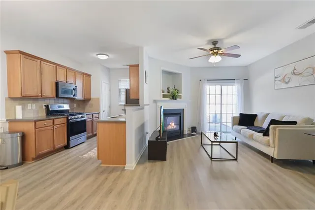 a open kitchen with furniture a refrigerator and a stove top oven