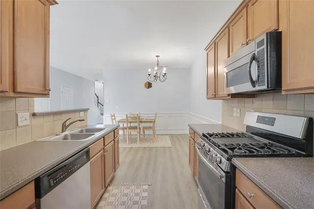 a kitchen with stainless steel appliances granite countertop a sink stove and cabinets