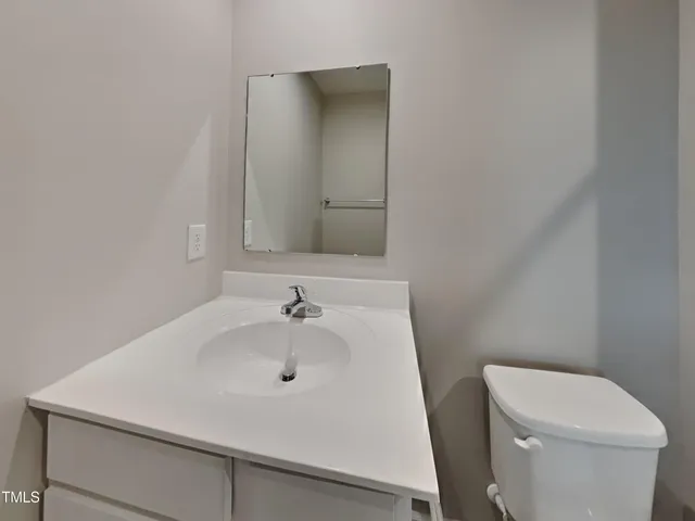 a bathroom with a sink a toilet and mirror