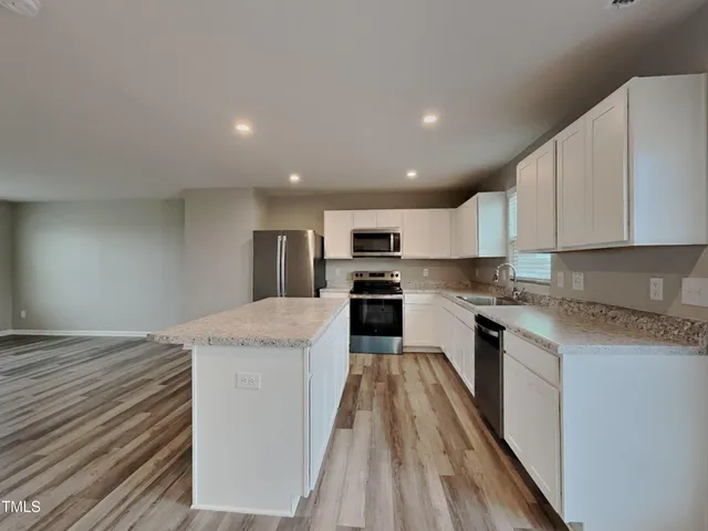 a large kitchen with a center island and stainless steel appliances