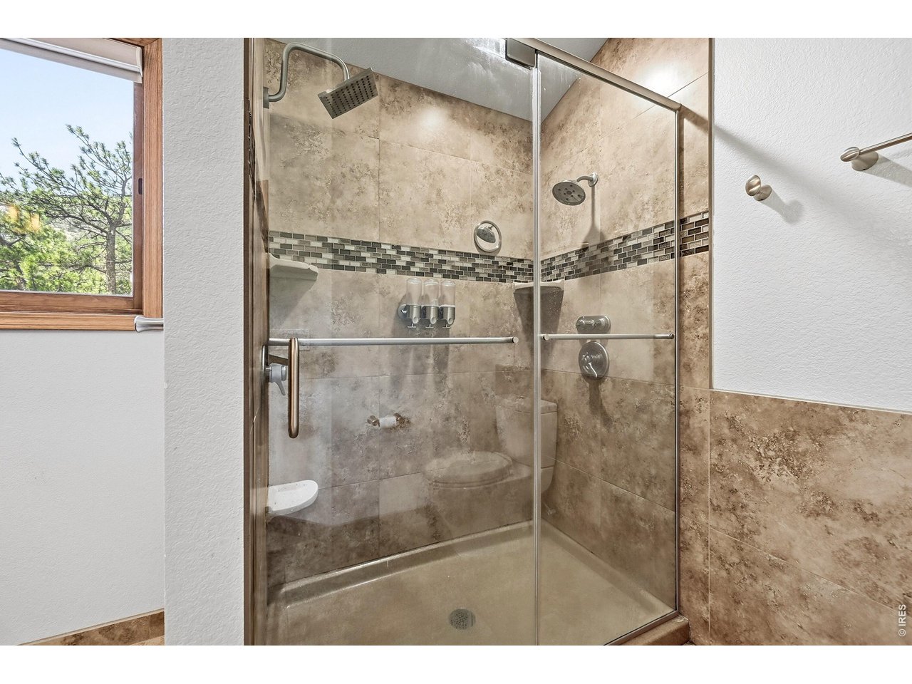 256 Choctaw Road Lyons, CO 80540 - Photo 31 of 50 a bathroom with a glass shower door