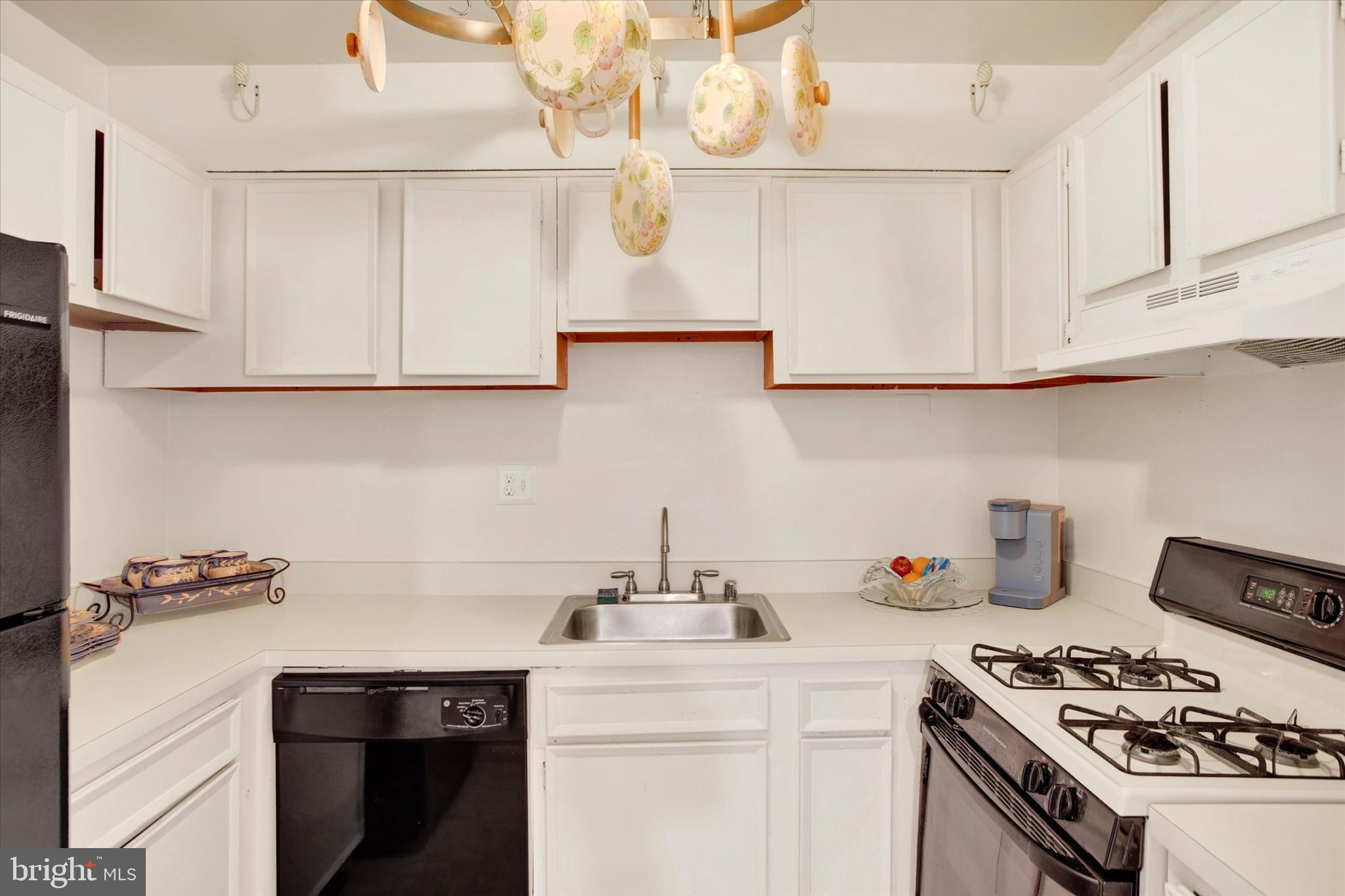 3805 Swann Road, Unit 304 Suitland, MD 20746 - Photo 7 of 16 a kitchen with kitchen island a sink a stove and cabinets