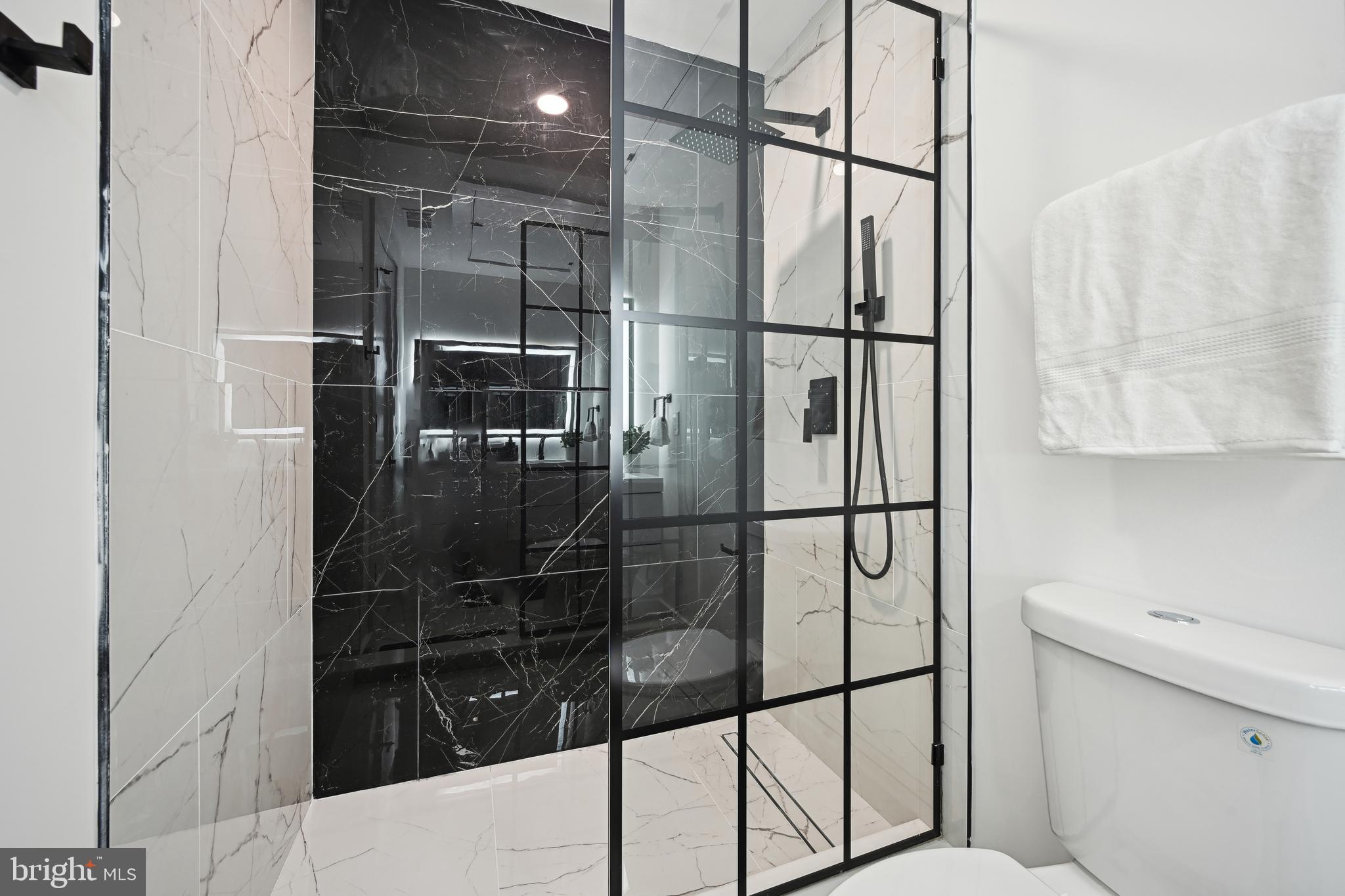 1372 Bryant Street Northeast, Unit 2 Washington, DC 20018 - Photo 18 of 22 a bathroom with a glass shower door
