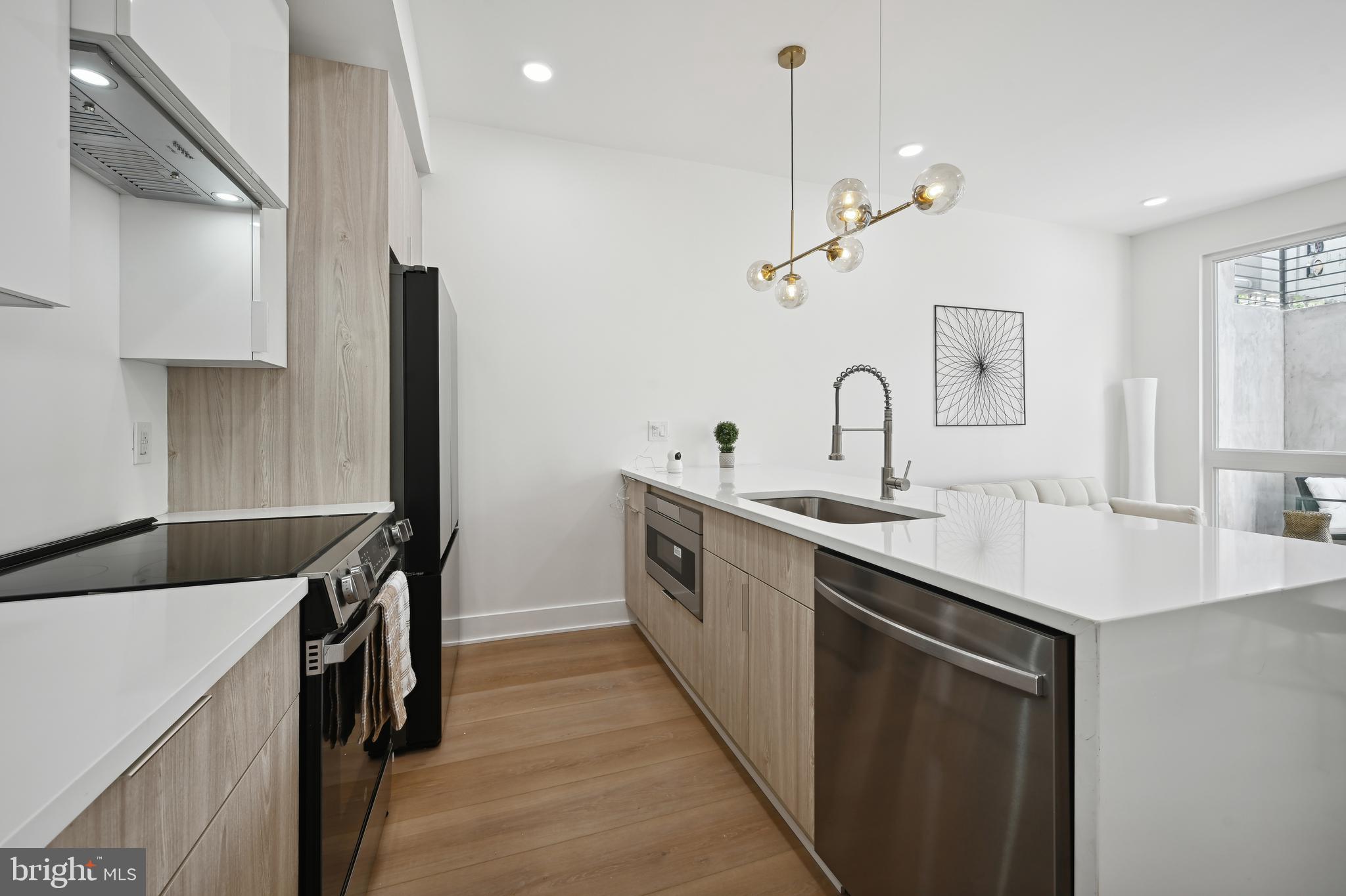 1372 Bryant Street Northeast, Unit 2 Washington, DC 20018 - Photo 9 of 22 a kitchen with a sink a counter top space stainless steel appliances and cabinets