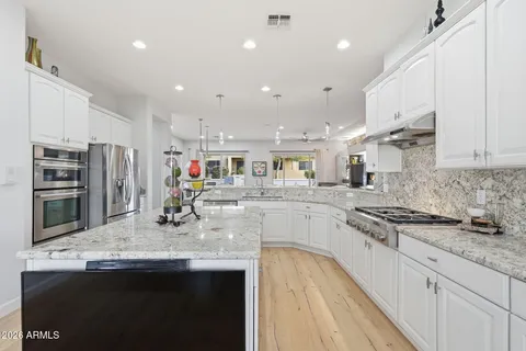 a kitchen with stainless steel appliances granite countertop a sink stove and refrigerator