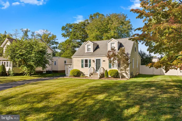 a view of a house with a big yard and large trees