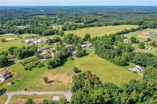 an aerial view of residential house with swimming pool and green space