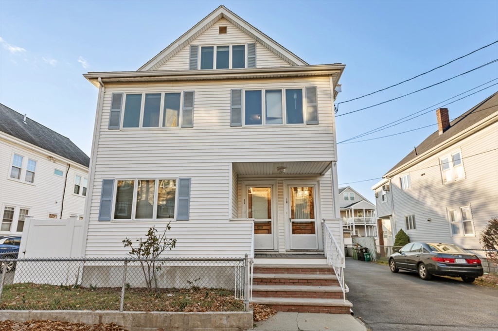 a front view of a house with a car parked