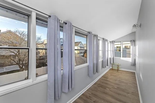 a view of a hallway with wooden floor and windows