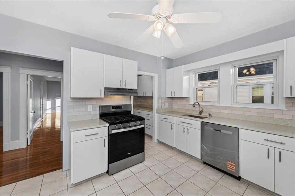 14 St Marys Street, Unit 2 Watertown, MA 02472 - Photo 5 of 14 a kitchen with granite countertop stainless steel appliances sink cabinets and window