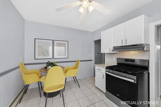 a kitchen with table chair and stove top oven
