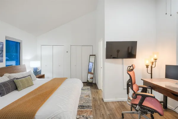 a bedroom with a bed and wooden floor