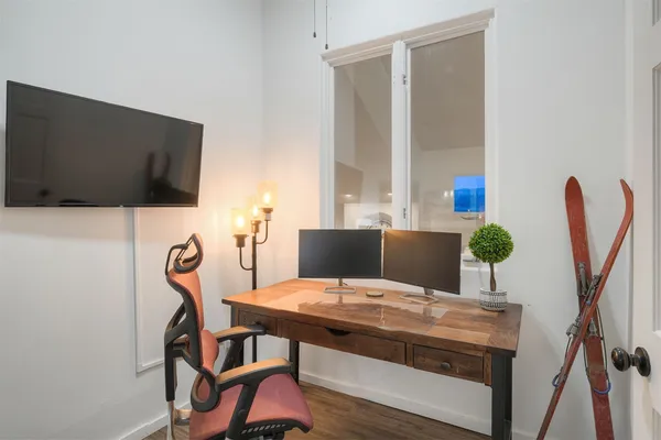 a bedroom with a bed and a flat tv screen on the wall