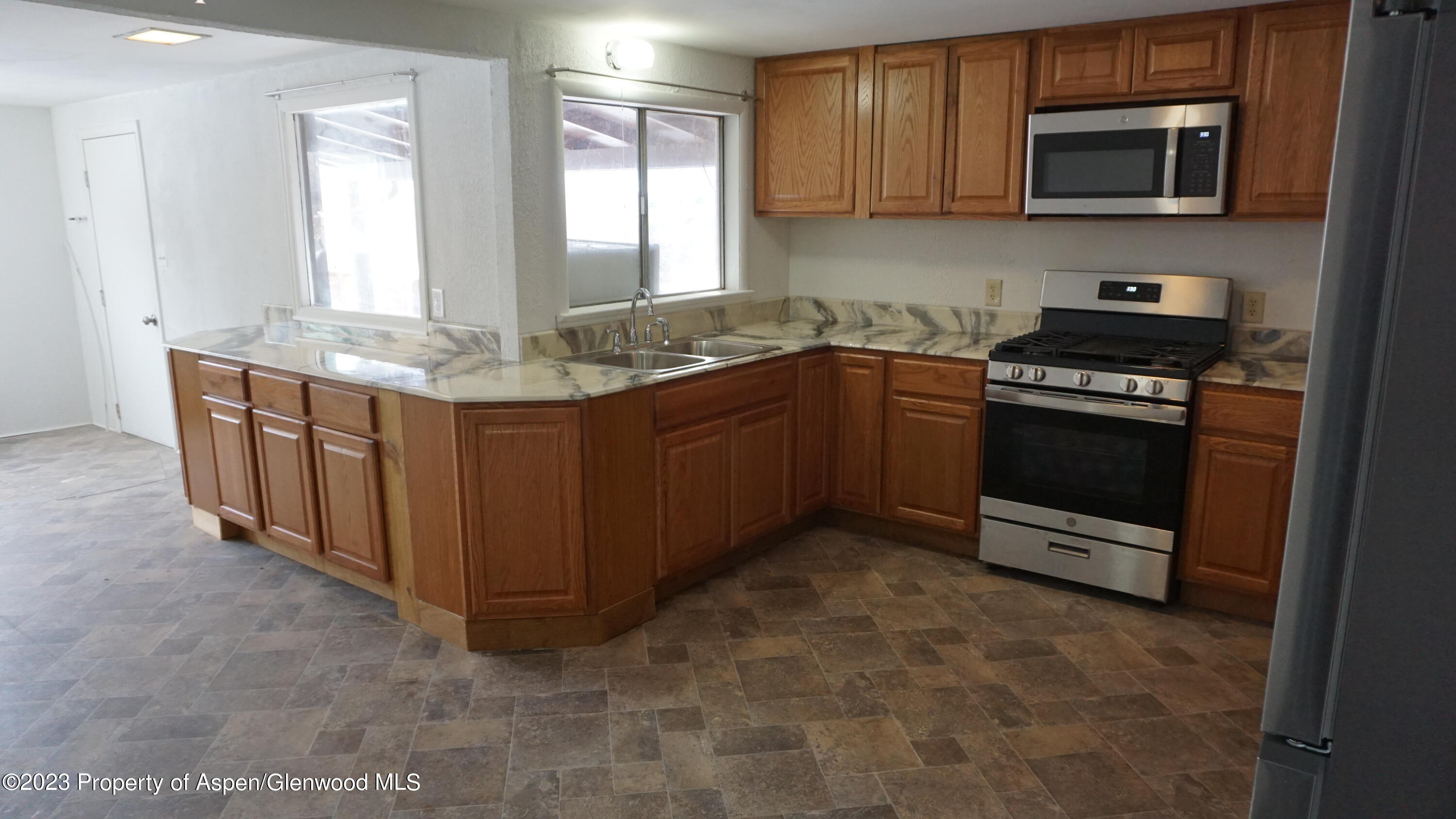 427 East 11th Street Rifle, CO 81650 - Photo 6 of 23 a kitchen with stainless steel appliances granite countertop a stove and a sink