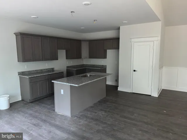 a view of empty room with fireplace and wooden floor