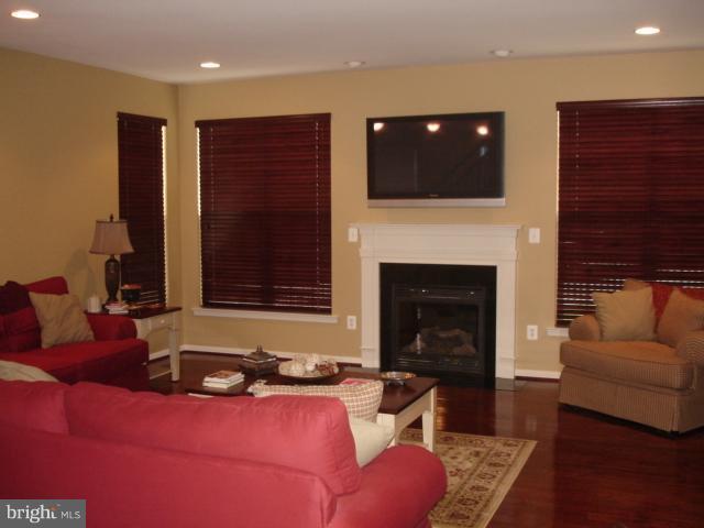 6554 Pebble Brooke Road Baltimore, MD 21209 - Photo 11 of 17 a living room with furniture a fireplace and a flat screen tv