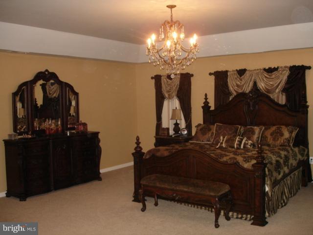6554 Pebble Brooke Road Baltimore, MD 21209 - Photo 15 of 17 a bedroom with furniture and a chandelier