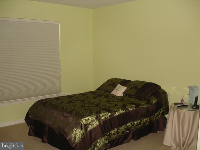 6554 Pebble Brooke Road Baltimore, MD 21209 - Photo 4 of 17 a bed sitting in a bedroom next to a wall