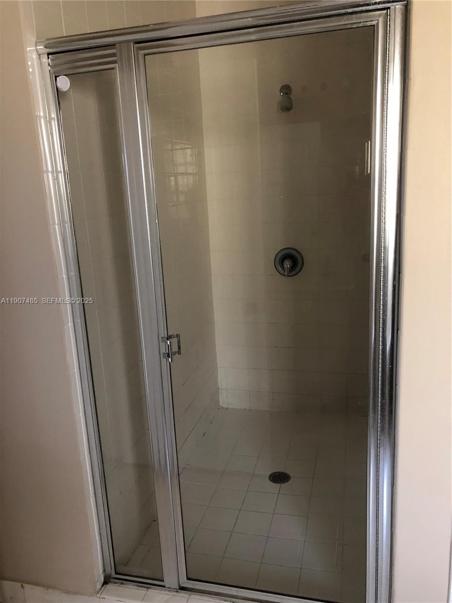 13426 Southwest 177th Terrace Miami, FL 33177 - Photo 27 of 36 a bathroom with a glass shower door